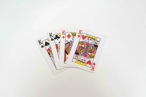 4 4 reyes en un fila jugando tarjetas, aislado en blanco foto