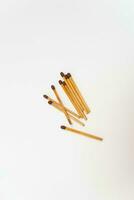 Row of red match sticks isolated on white background. Burnt matches and whole matches on white background. photo