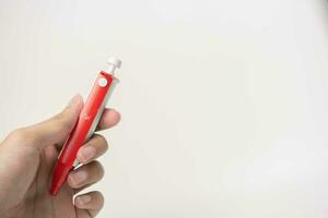 hembra mano con lanceta bolígrafo en blanco antecedentes. diabetes concepto foto
