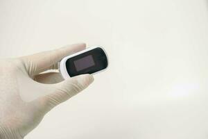 Close up of human finger while using Pulse Oximetry isolated on white background. photo