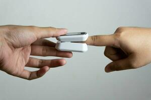 Close up of human finger while using Pulse Oximetry isolated on white background. photo