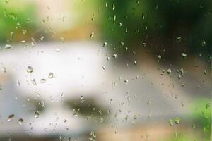 View of glass with water drops on window bedroom, closeup. Rain drops sliding on window glass photo