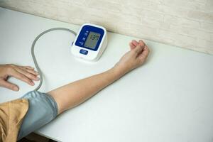 Young woman measuring his blood pressure at home. self blood pressure and heart rate photo