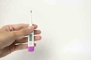 Female hands holding a digital thermometer. Girl measures the temperature. Fever and healthcare concept photo