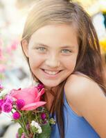 adorable contento joven azul ojos niña participación un Fresco cortar floral ramo de flores a el agricultores mercado. foto