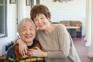 Happy Senior Chinese Couple Pose for Their Portrait On The Porch. photo