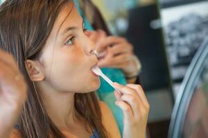 joven niña muestreo un gusto de helado a el hielo crema tienda. foto