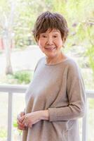 Happy Senior Chinese Woman Poses for Her Portrait Outdoors. photo