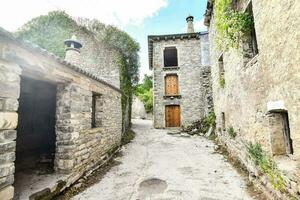 un estrecho callejón con Roca edificios y un puerta foto