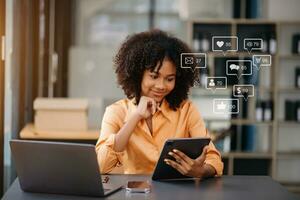 Asian woman typing smartphone, keyboard  with laptop computer of Social media and Marketing virtual icons screen concept. photo