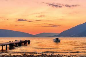 hermosa puesta de sol con muelle y pescar barco foto