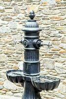 a black water fountain with two water bowls on top photo