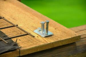 a wooden table with a screw and a nail photo