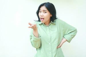 studio shot of angry asian woman standing over isolated white background with raising palms and hands on waist looking at camera show questioning gesture and mad expression photo