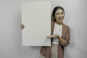 sonriente joven asiático mujer empleado participación y demostración vacío blanco junta, aislado por blanco antecedentes foto
