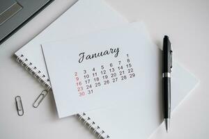 January calendar page on office desk photo