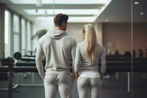 Couple in matching sportswear standing in a gym.Generative AI photo