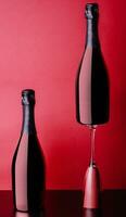 concept of two bottles and glass of red rose champagne photo