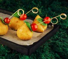 Tasty cheese balls pear-shaped with tomatoes photo