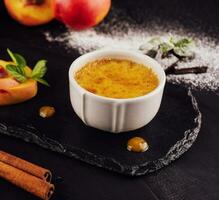 cup of creme brulee with apricot pieces photo