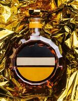bottle of cognac on gold foil photo