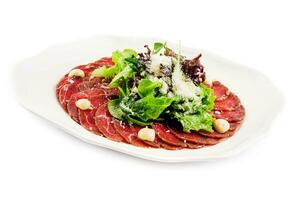 ternera carpaccio con parmesano queso en blanco plato foto