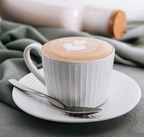 cerca arriba de taza de café con corazón flor pintado en espuma foto