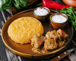 Traditional Moldavian, Romanian cornmeal porridge with meat and sauce photo