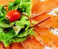 Slices of raw salmon fillet on white plate photo