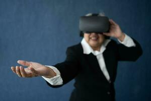 Senior Business woman wearing smart virtual glasses for Video conferences, VR  headset glasses technology in modern offices and open the palm of the hand. Metaverse concept. photo