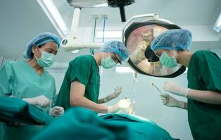 Asian Professional surgeons team performing surgery in the operating room, surgeon, Assistants, and Nurses Performing Surgery on a Patient, health care cancer and disease treatment concept photo