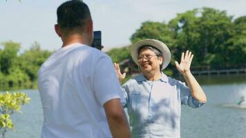 contento y sano parejas asiático foto y vlog selfie juntos para social medios de comunicación en parque en ocio. familia y amistad estilo de vida, disfrute de activo personas mayores, y al aire libre actividad después Jubilación