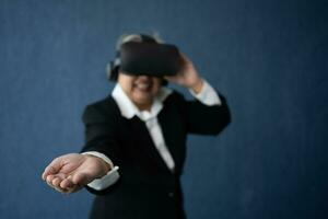 Senior Business woman wearing smart virtual glasses for Video conferences, VR  headset glasses technology in modern offices and open the palm of the hand. Metaverse concept. photo