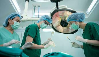 Asian Professional surgeons team performing surgery in the operating room, surgeon, Assistants, and Nurses Performing Surgery on a Patient, health care cancer and disease treatment concept photo