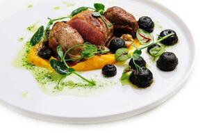 Grilled duck breast on mango puree with drops of prune jam photo