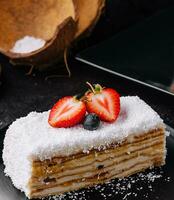 Coconut Cake slice with strawberries and blueberries photo