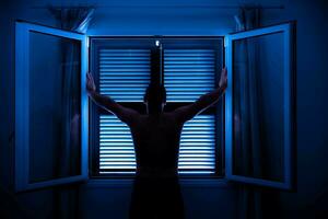 unrecognizable man face up with arms raised in front of window photo