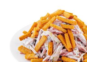 Salad with croutons and mayonnaise on plate on white background photo