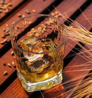 a glass of whiskey in a wheat field photo