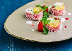 rolls of pink pancakes with different fruits and berries photo