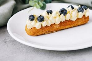 Tasty French eclairs with cream and fresh berries photo