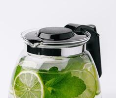 Fruit water with lime and mint in glass pitcher photo