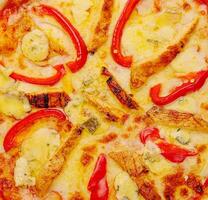 A top view of cheesy chicken pizza with sliced red bell pepper photo