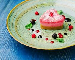 heart shaped raw vegan red cake with raspberries photo