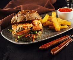 Burger with salmon, lettuce and fried potato photo