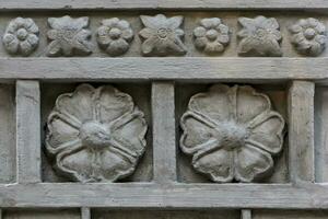 Close-up shot of a stone wall with a simple hand carved carver. photo