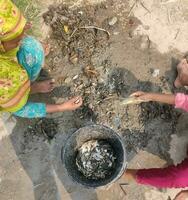 A picture of a village in Bangladesh where some people are fishing from a canal photo