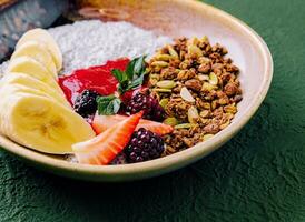 sano desayuno cuenco de Granola, yogur y frutas foto