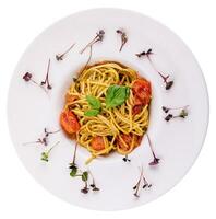 Spaghetti with colorful stewed cherry tomatoes, basil and pesto sauce photo