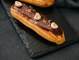 french eclairs with chocolate and hazelnuts photo